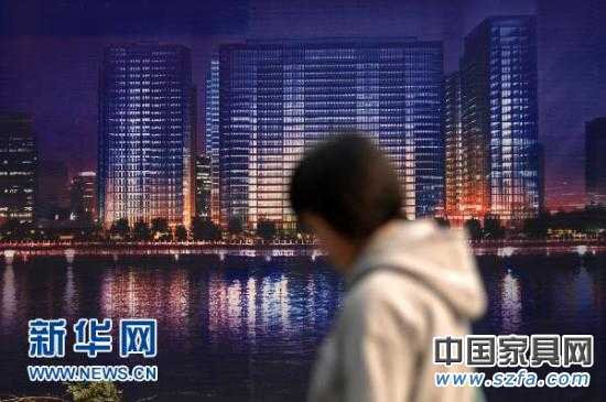 一位市民從杭州市區(qū)的一處商業(yè)樓盤廣告牌前走過(guò)（2010年11月4日攝）。新華社記者 黃宗治 攝 